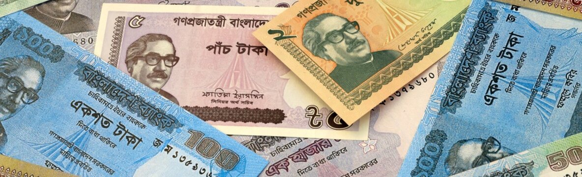 Bangladeshi taka money bills in pile on table. Bangladesh BDT currency cash close up