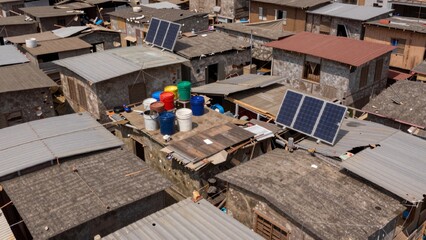 Fototapeta premium Aerial slum area multiple houses made corrugated metal sheets have sloping roof there several solar panels whi