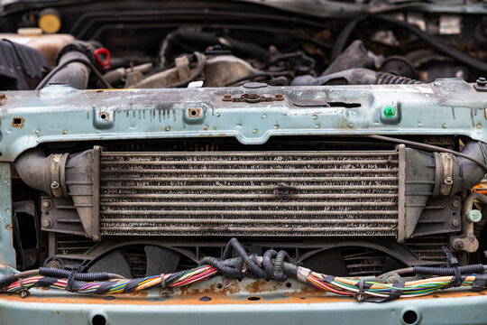 Car engine bay close up with radiator intercooler and wires in old vehicle