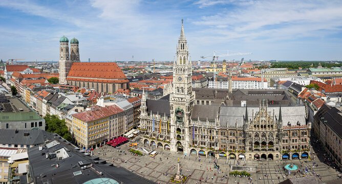 Aerial view of the historic Marienplatz featuring the Neues Rathaus and the iconic Frauenkirche towers surrounded by urban architecture in Munich, Bavaria, Germany.
