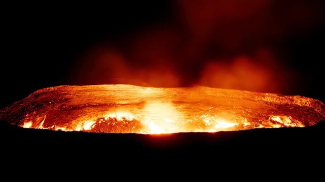 Volcanic eruption with lava and smoke at night.