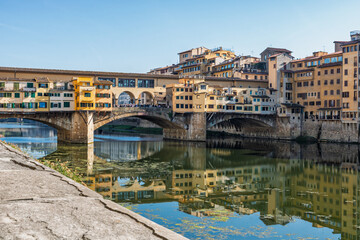 Fototapeta premium Famous historic Ponte Vecchio bridge and old buildings along the Arno river in Florence Italy