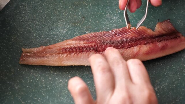 Removing belly and small bones from fish fillets in the kitchen
