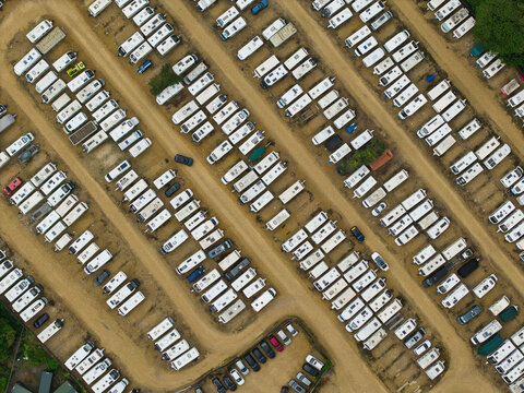 Aerial view of Weldon Caravan Storage with rows of parked caravans and motorhomes on a gravel lot in Weldon, England, United Kingdom.