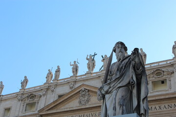 Obraz premium VATICAN CITY - JUNE 6, 2016: Statue of Saint Paul in front of St. Peter's Basilica facade under blue sky