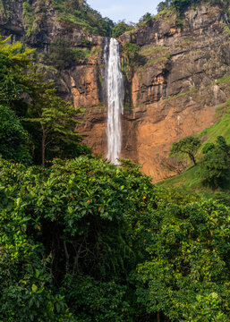 Aerial view of Cikanteh Waterfall cascading down a steep rocky cliff surrounded by lush tropical rainforest in Geopark Ciletuh, West Java, Indonesia.