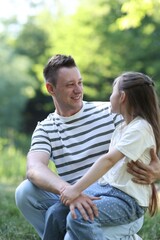 Fototapeta premium Smiling father and his daughter looking at each other outdoors