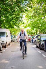 Naklejka premium Mature man cycling in city street