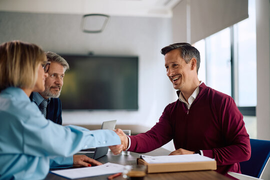 Happy businessman accepting job offer during meeting in office.