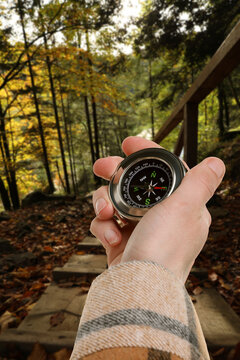 Tourist using compass to find way outdoors, closeup