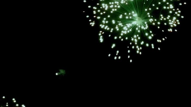 Breathtaking fireworks illuminate dark canvas of New Year's Eve night. Emerald and crimson sparks cascade across sky, creating mesmerizing spectacle of light color during joyful Christmas celebration.