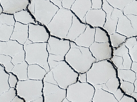 Aerial view of the cracked hexagonal patterns and white mineral crust of the Uyuni Salt Flat in Potosi Department, Bolivia.