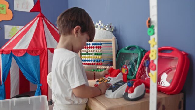 Boy with abacus and toy cash register, hands pressing buttons and clapping, in building; curiosity learning imagination.