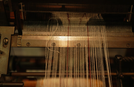 Threads are stretched across a historic loom, detail