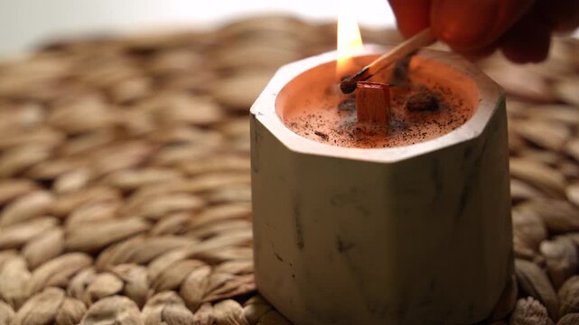 Light a candle with a match and a wooden wick