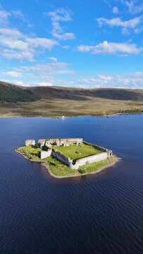 Lochindorb Castle in the Scottish Highlands, Scotland, appears in a far-view photograph showing the 13th-century ruins as a small island fortress set within the wide expanse of Lochindorb