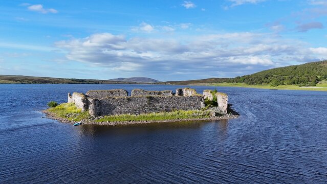 Lochindorb Castle, built in the 13th century in Scotland, stands on a small island in the Scottish Highlands and is shown in a side-view aerial photograph captured at a 45-degree angle, highlighting i
