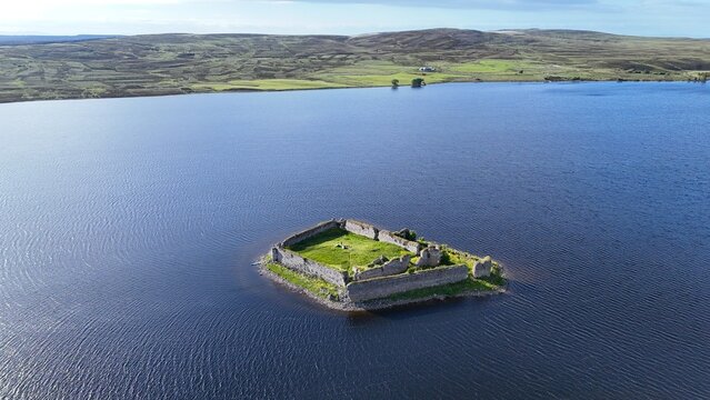 This aerial view captures Lochindorb Castle, a 13th-century medieval fortress at Lochindorb in the Scottish Highlands,scotland  standing isolated on an island amid serene waters.