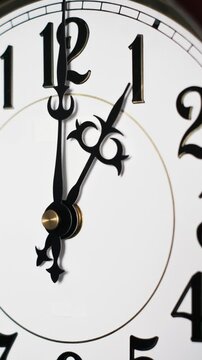 Vertical time-lapse close-up shows ornate hands spinning rapidly on a white analog clock face. Concept of deadline urgency, business schedules, passing time, and effective time management.