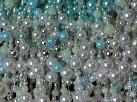 multicolored beads, colored pearl beads in white and blue tones, textured background