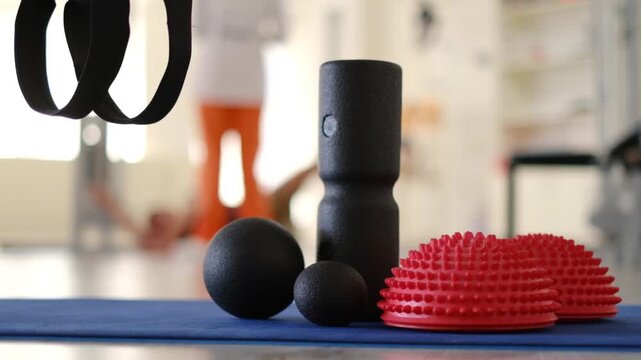 Foam roller, massage ball and balance dome on fitness mat in gym studio for workout and stretching.
