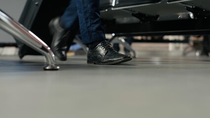 Obraz premium Walking, trolleys close up shot and tourists in busy airport departure terminal, preparing to fly home, baggage and people navigating through chairs rows.