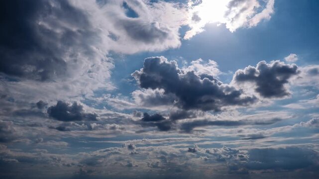 Timelapse captures dense dark storm clouds ominously moving across a blue sky. The brief moments of light create a moody and dramatic atmospheric weather display.