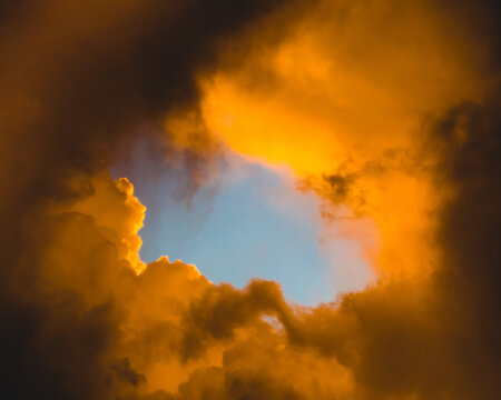 Fiery Orange Storm Clouds Parting Over Blue Sky