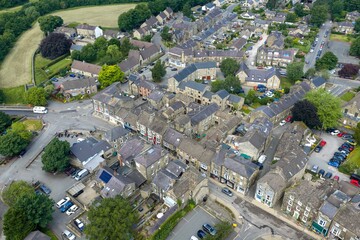 Aerial view of Pateley Bridge town centre in North Yorkshire showing traditional stone buildings shops residential streets parked cars and surrounding countryside captured from above on a summer day © Duncan