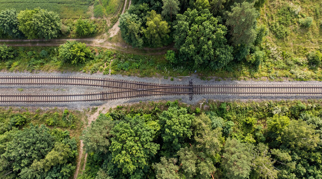 Two Parallel Industrial Train Tracks Merging Elegantly Into One Single Perfectly Straight Aligned Railway Line
