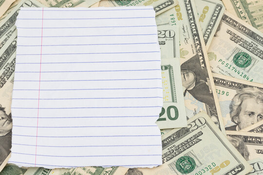 Blank lined paper with twenty dollar bill cash