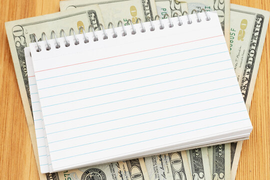 Money with blank index cards on wood desk