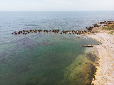 Aerial view of concrete anti-tank obstacles known as dragon's teeth submerged in the Black Sea along the rocky coastline of Durankulak, Dobrich Province, Bulgaria.