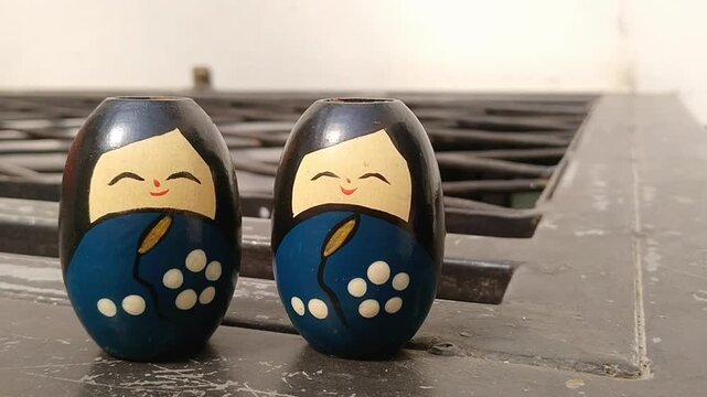 Close up of two vintage handmade wooden Kokeshi dolls with beautiful colorful patterns