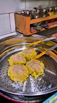 Lifting a steaming hot jumbo dim sum from a traditional bamboo steamer basket, authentic Asian culinary and street food concept.