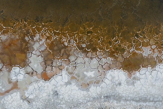 Aerial view of the intricate salt flat patterns with textured mud and mineral deposits in La Ventana, Baja California Sur, Mexico.