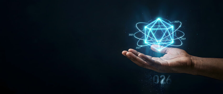 Human hand holding glowing geometric crystal hologram with orbital ring on dark background