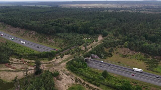 Wildlife crossing overpass spanning a busy highway aerial view