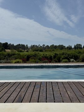 Modern swimming pool overlooking lush greenery under a dramatic sky, creating a serene luxury retreat atmosphere.