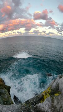 Slow motion fisheye video of Bondi Beach viewed from a coastal lookout at sunset, with calm ocean water, soft golden light, and the Sydney coastline, Australia.