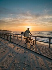 Fototapeta premium Surfer rides bicycle on boardwalk at sunset with surfboard under arm