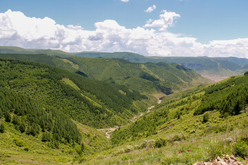 Fototapeta premium Scenic mountainous landscape with green valleys and cloudy sky