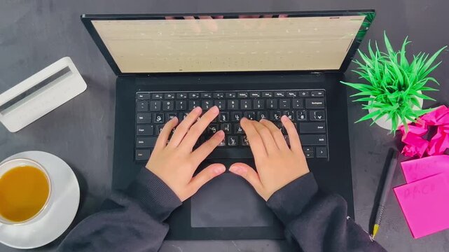 Top view of typing on laptop, 16:9 widescreen footage, working at desk, office environment, professional workspace, digital workflow, computer keyboard, productive lifestyle, study session.