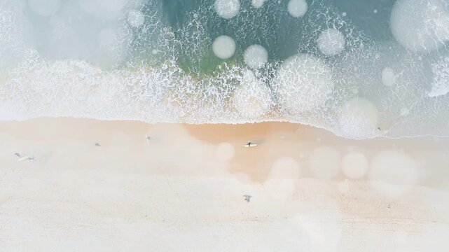 Incoming swell sending waves, beach showing paddling surfers and walkers, revealing calm rhythm