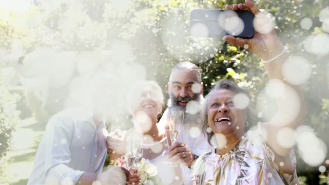 Bokeh clearing woman raising phone and group leaning in taking event selfie with flutes and bouquet