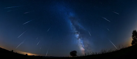 Meteor Shower Over Milky Way: A breathtaking panoramic view captures a vibrant meteor shower streaking across the starry night sky. © 琛明 周