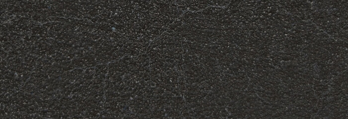 Fototapeta premium Black asphalt texture background, grainy dark road surface close up, charcoal gray stone pavement material for construction and urban design