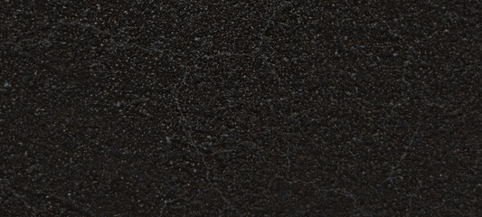 Fototapeta premium Black asphalt texture background, dark grainy road surface material, rough charcoal stone pavement for construction and architectural design