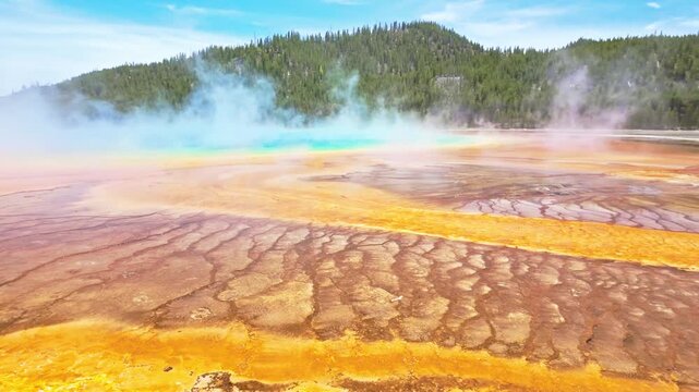 Vivid rainbow colored mineral rings of Grand Prismatic Spring viewed up close from the wooden boardwalk