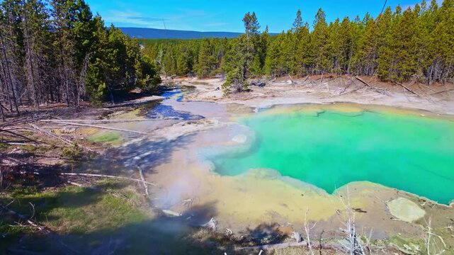 A vivid turquoise geothermal pool highlights the unique landscape of Norris Geyser Basin in Yellowstone National Park